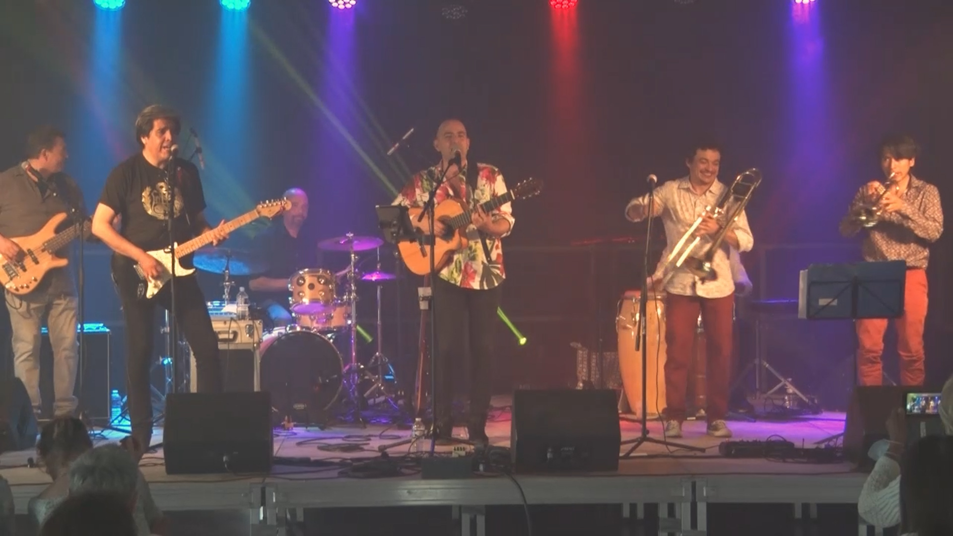 With five musicians and their instruments playing on stage.